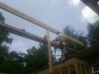 Carpenter setting a ridge beam over a new addition frame — Ice Dam Removal by Roofing Brothers in North Liberty